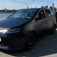 A photo of the Sion electric car with the New York skyline behind.